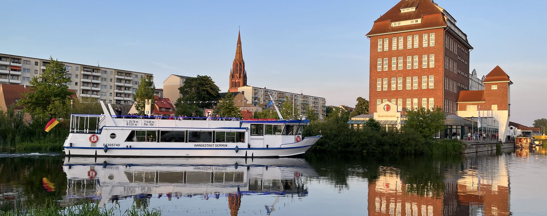 Aufnahme über die Peene auf Demmin. Im Hintergrund die Kirche. Auf der Peene ein Fagrgastschiff