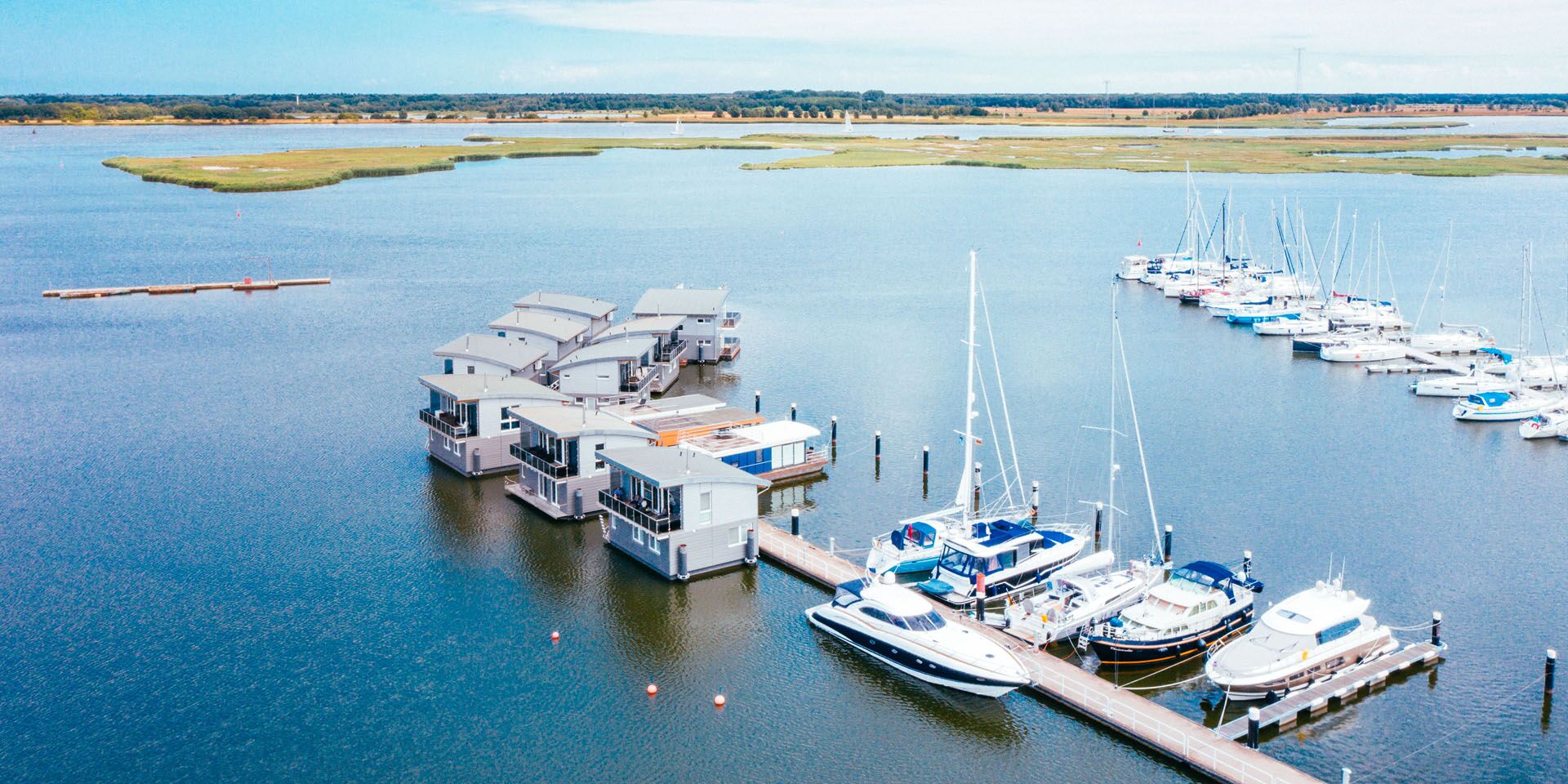 Luftaufnahme über der Marina Kröslin, in der Hausboote und Segelboote liegen