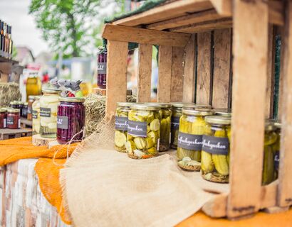 Homemade cucumbers in glasses are in an old wooden box, behind it in the picture other self -made products