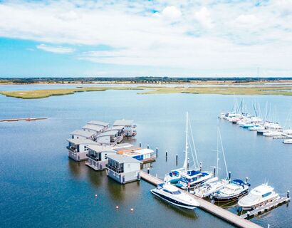 Luftaufnahme über der Marina Kröslin, in der Hausboote und Segelboote liegen