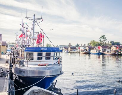 Ein blaues Fischerboot aus Metall im Hafen Freest