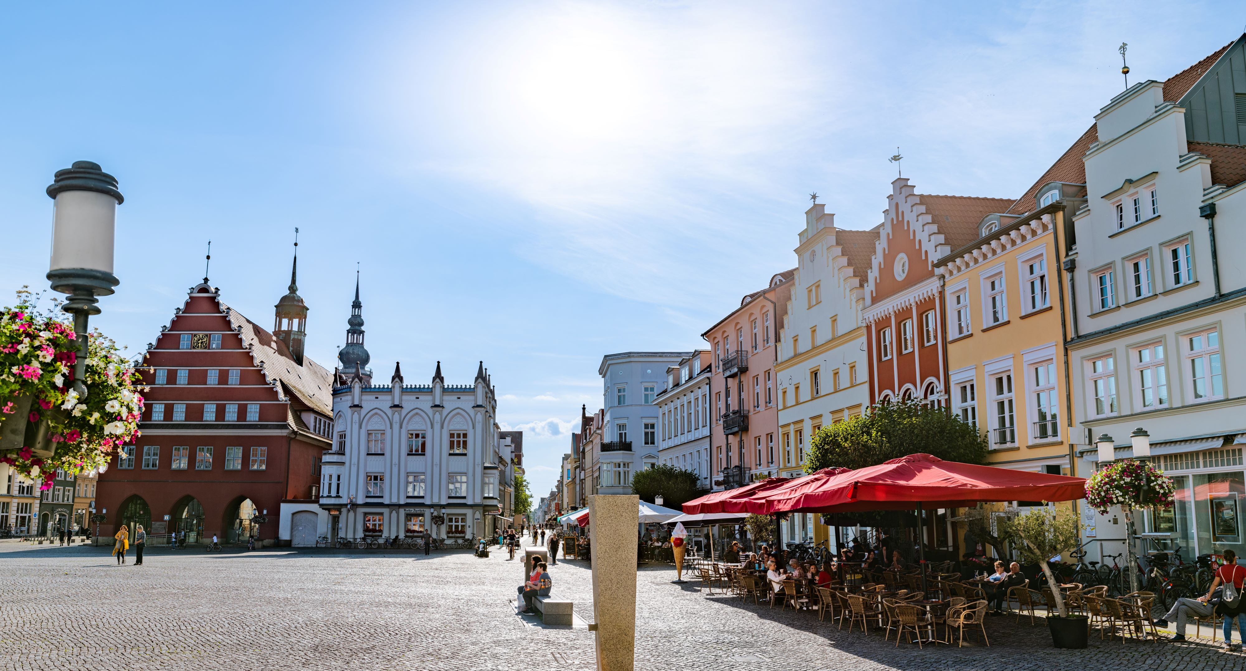 Der Greifswalder Marktplatz mit Gastronomie und dem roten Rathaus inklusive der Greifswald-Information