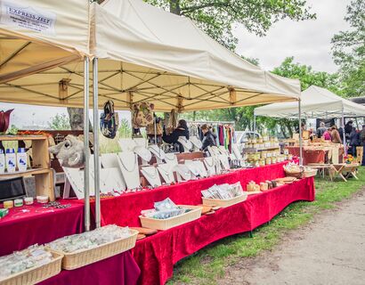 A large -scale stand under a tent. The stand has jewelry and other products on offer