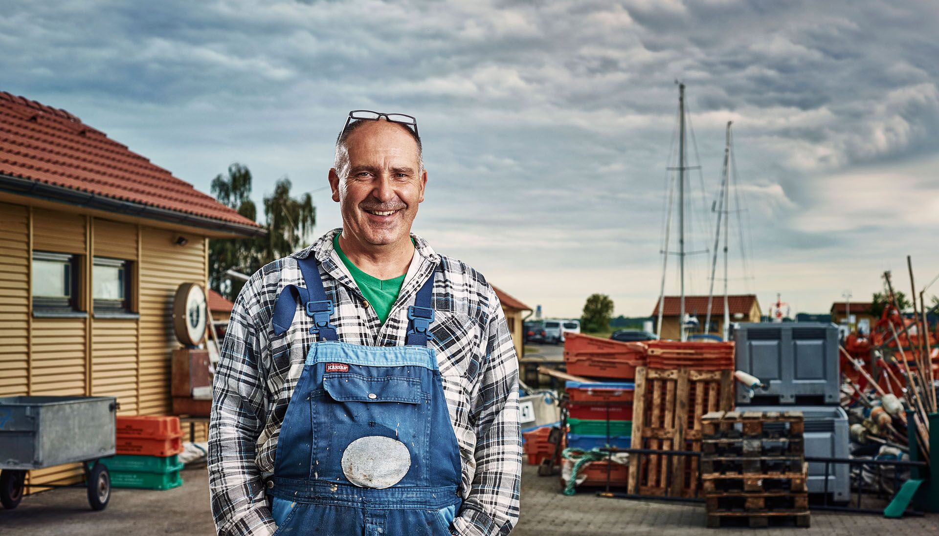 The fisherman Dirk Baumann with blue dungarees over a blue and white-checked flannel shirt.