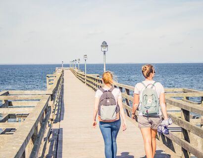 Zwei Frauen gehen über die Seebrücke Lubmin am Tag bei Sonne