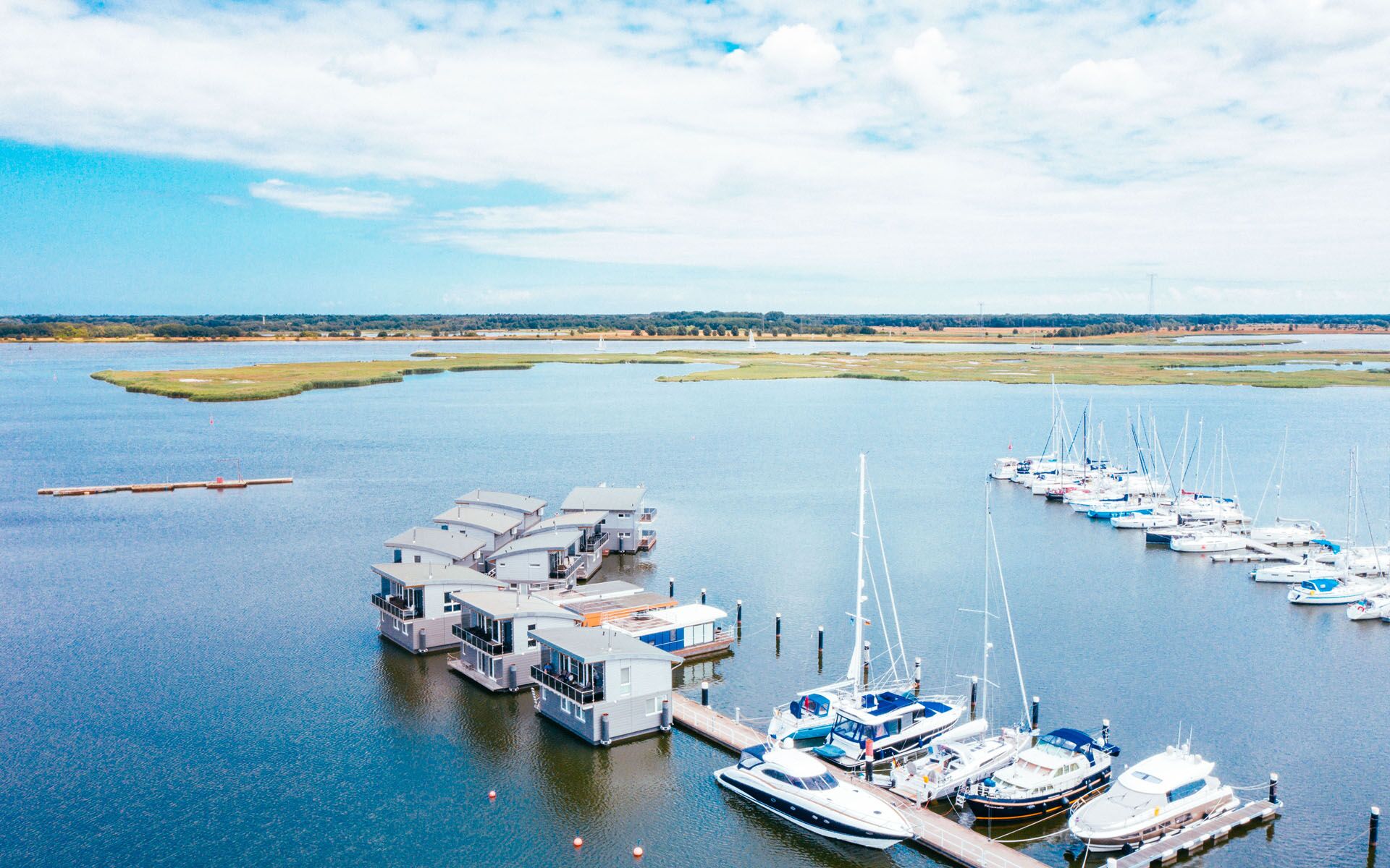 Luftaufnahme über der Marina Kröslin, in der Hausboote und Segelboote liegen